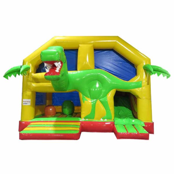 Une maison gonflable colorée conçue pour ressembler à un dinosaure, mettant en vedette un dinosaure vert avec la bouche ouverte, entouré de murs jaunes et bleus. Il comprend des accents de palmiers et un toboggan sur le côté droit, appelé Château Combo gonflable Maman dino.