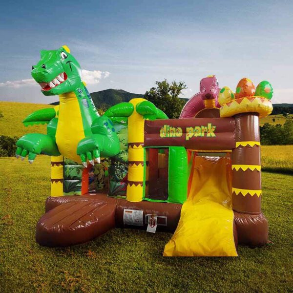 Une maison gonflable colorée en forme de dinosaure est installée à l'extérieur sur un terrain herbeux. Il comprend un grand dinosaure vert, un petit dinosaure violet et un toboggan. La mention « CHÂTEAU GONFLABLE DINO PARK » est imprimée sur le devant. Des arbres et des collines sont visibles en arrière-plan.