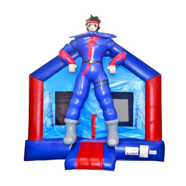 Une maison gonflable bleue et rouge avec une grande figurine de super-héros animée debout au sommet. Le super-héros a les cheveux hérissés, un costume bleu et rouge et de grandes bottes grises. La structure possède deux fenêtres et une petite entrée avec des escaliers qui y mènent – CHÂTEAU GONFLABLE SUPER HÉROS.